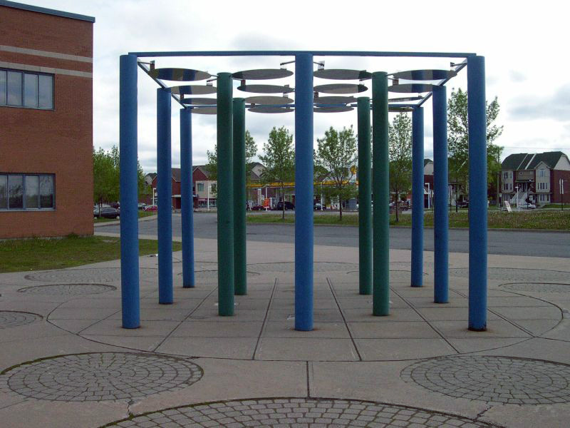 <strong><i>La Place moléculaire</i></strong><BR>1990<BR>Sculpture-cinétique et aménagement, acier peint et inoxydable<BR>13 colonnes de 3 m de hauteur, 20 cm de diam., 16 disques de 80 cm. de diam.<BR><i></i><BR><BR><h9 style='font-size:.8em'>Photo : 3/6</h9><BR><br><br><h9 style='font-size:.8em'>© Succession Charles Daudelin /COVA-DAAV